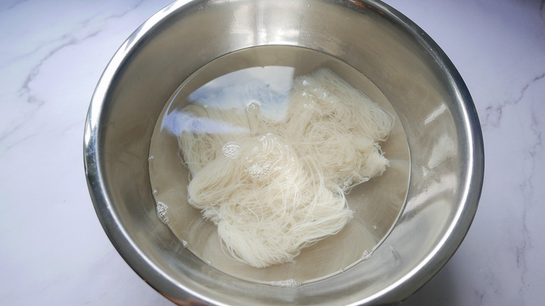 Rice vermicelli soaking in a steel bowl