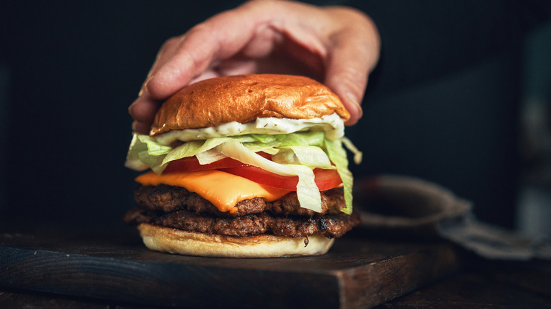 A burger with lettuce, tomato, and cheese