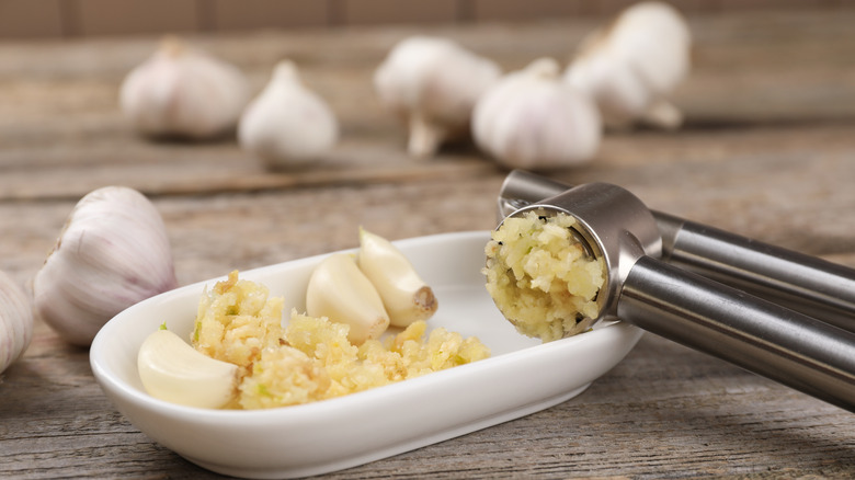 Pressed garlic and cloves in a white dish