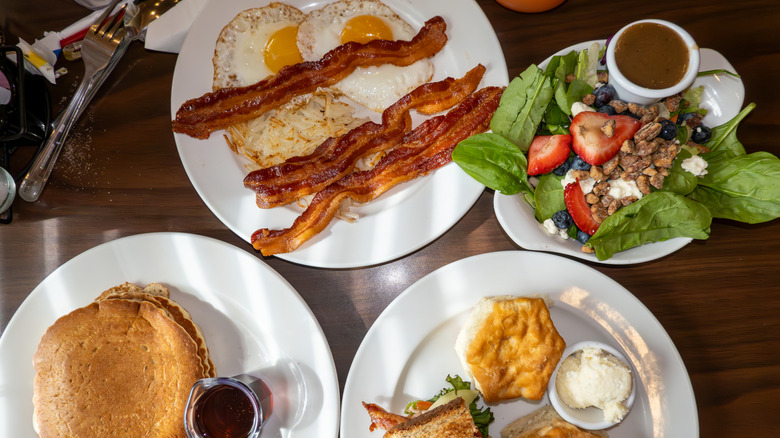 A display of diner food, eggs and bacon, pancakes, and salad