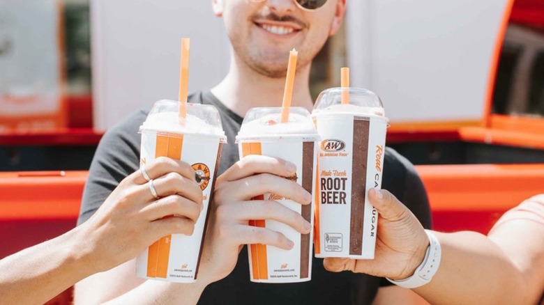 friends toasting with A&W milkshakes