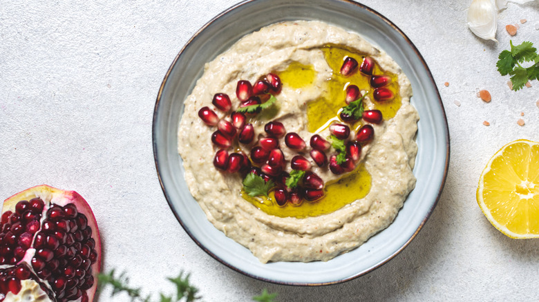 A dish of baba ghanoush with pomegranates