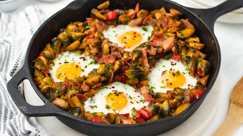 Brussels sprouts hash with eggs in skillet