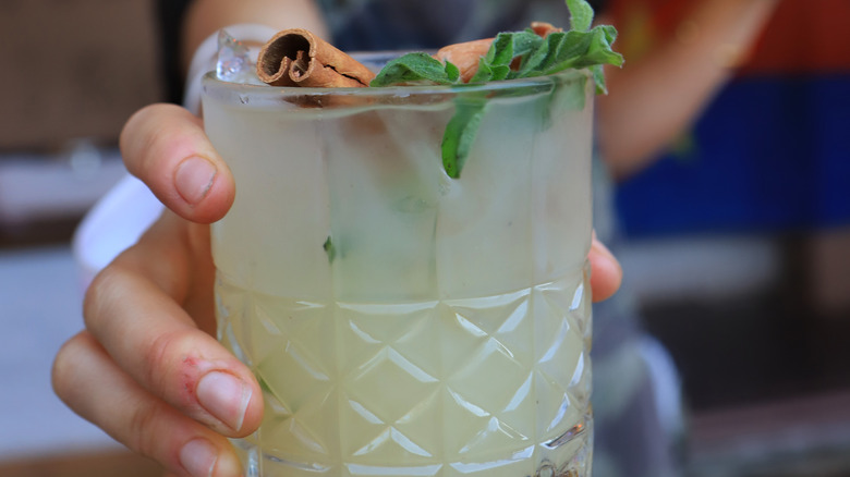 Hand holding cocktail in glass