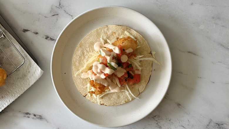 Fried fish taco with pico de gallo and crema
