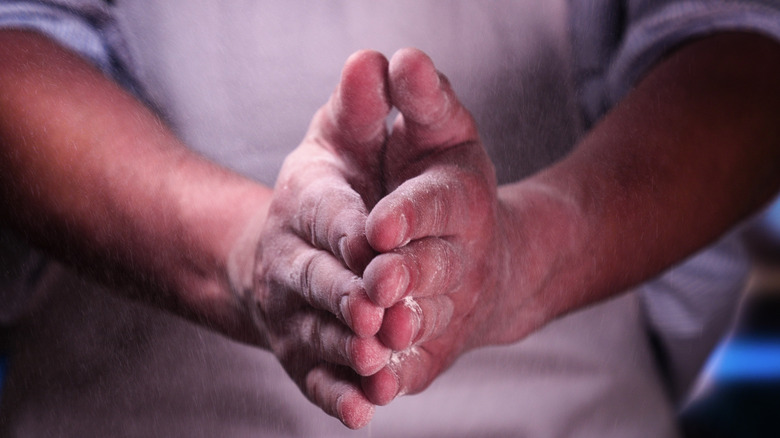 hands covered in flour clapping