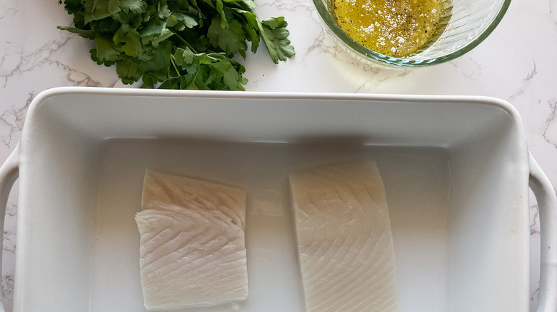 Fish fillets with lemon, oil sauce, and parsley