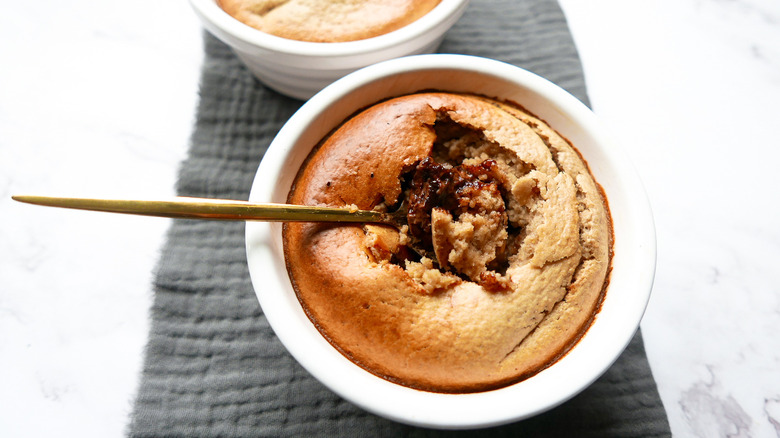 Baked oatmeal in ramekin with spoon breaking top