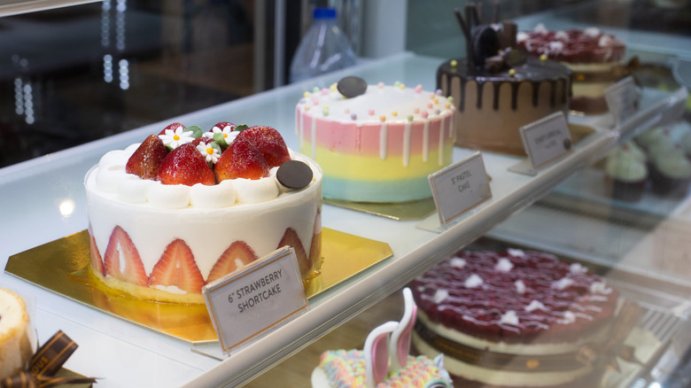 Several cakes on display behind a glass case