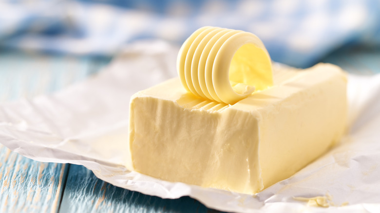 Butter in packaging with a slice on top