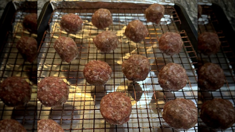 Baked meatballs on a wire rack.