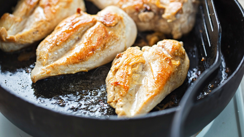 Chicken breast cooking in pan