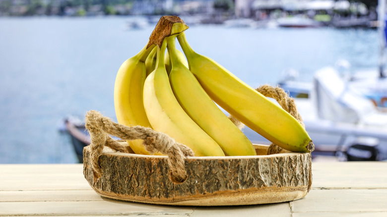 Bananas with sailboat on water in background