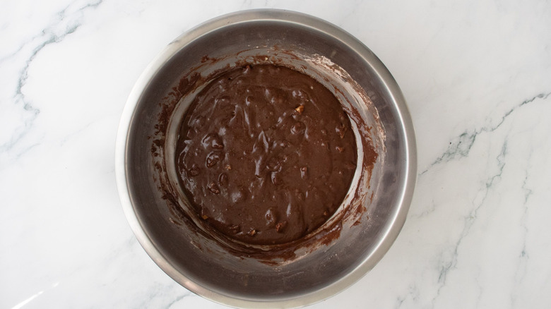 Brownie batter with chopped walnuts in bowl