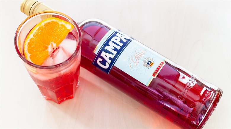 Campari bottle next to cocktail