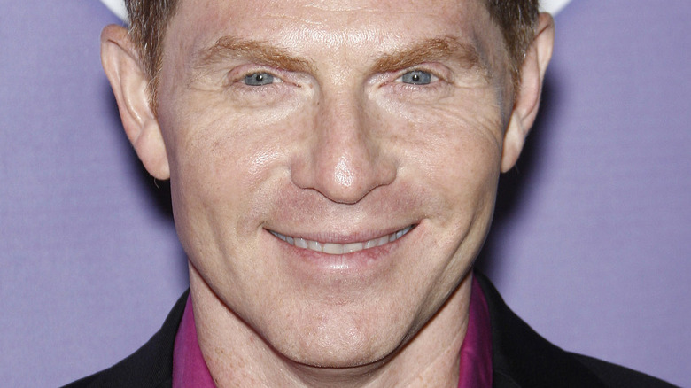 Bobby Flay smiling against purple background