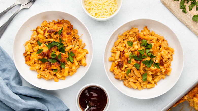 Two bowls of BBQ chicken mac & cheese, garnished with parsley
