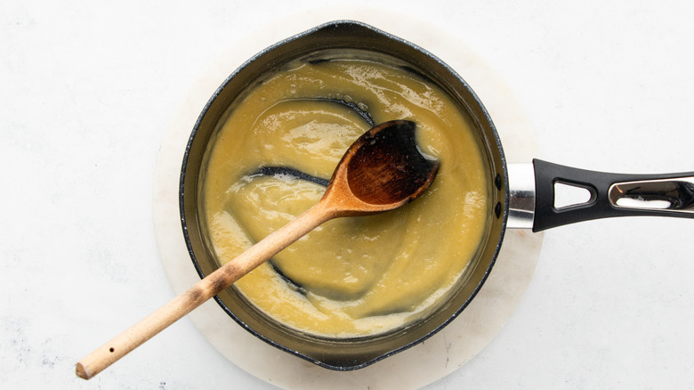 Butter and flour mixture in saucepan with wooden spoon