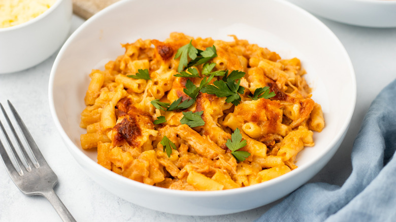 BBQ chicken mac & cheese in white bowl with parsley garnish