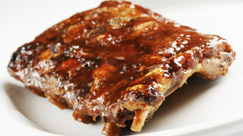 Rack of barbecue ribs on white plate