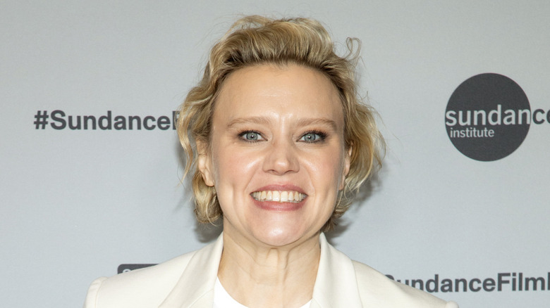 Kate McKinnon wearing a white jacket