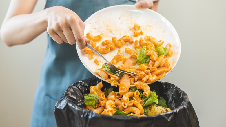 Food being scraped into the trash