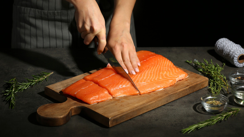 A person cutting a fish