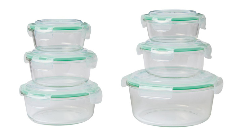 Empty glass bowls with green-trimmed lids on display