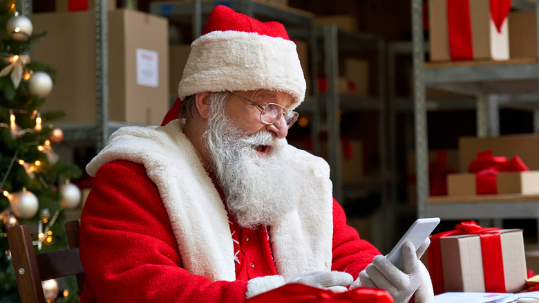 Santa laughing while looking at phone