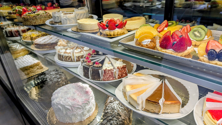 Colorful assorted pastries and cakes in a glass display case at Teixeira's Bakery