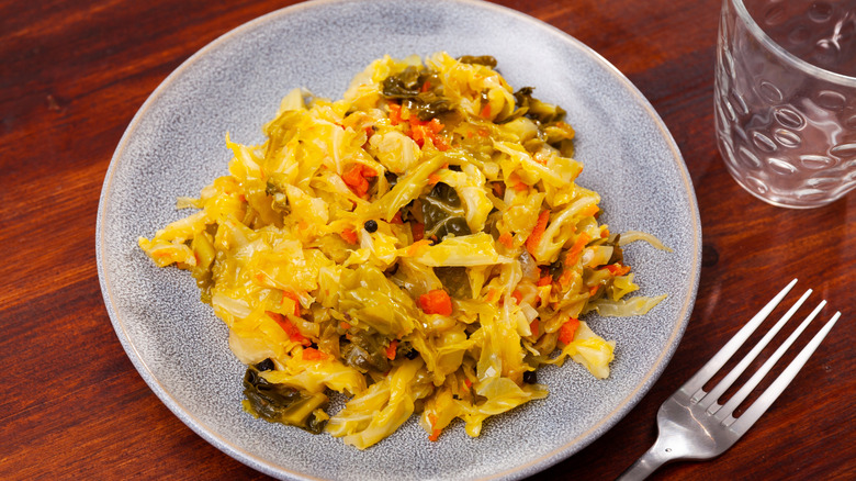 Braised cabbage with vegetables on a ceramic plate.