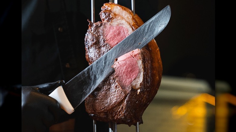 meat being sliced by a gaucho