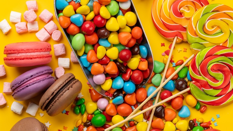 Variety of candies on yellow background
