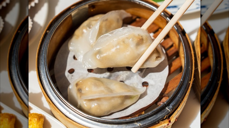 chopsticks holding a dumpling