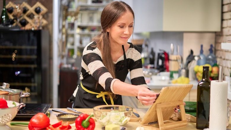 woman using cookbook in kitchen