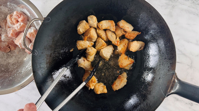 Chicken pieces cooking in wok