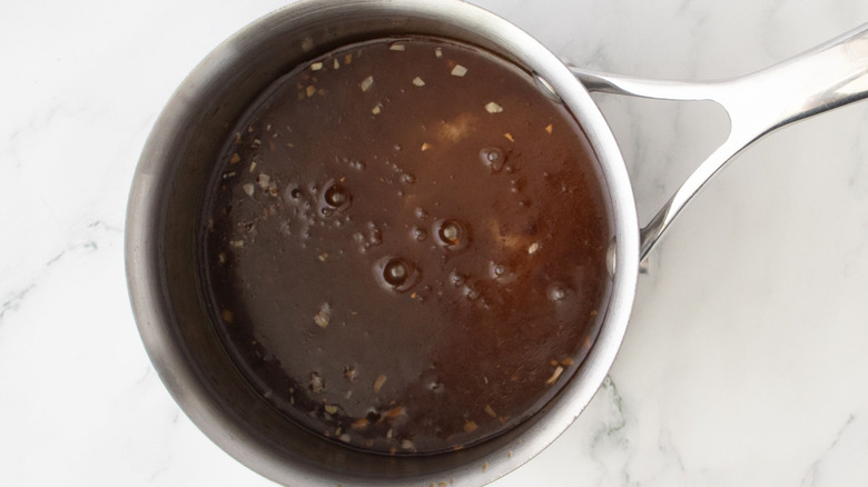 Teriyaki glaze in saucepan on marble surface