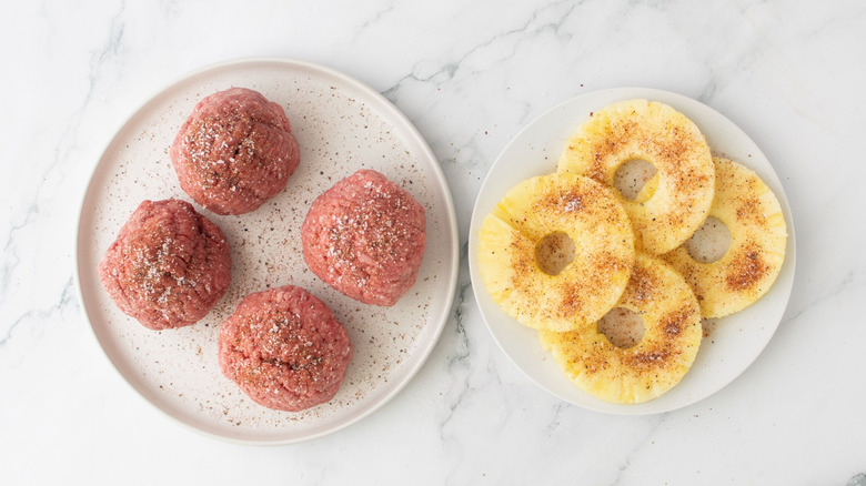 Seasoned ground beef balls and seasoned pineapple rings on plates