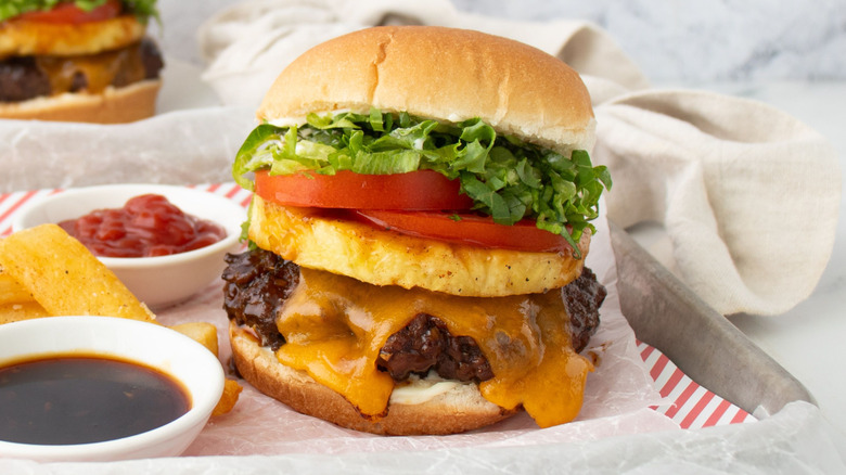 Closeup of Banzai burger next to fries, ketchup, and teriyaki sauce