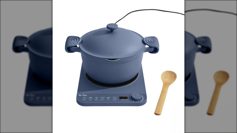 Gray-blue hot pot with induction cooker, wooden spoon on the side, against a white background.