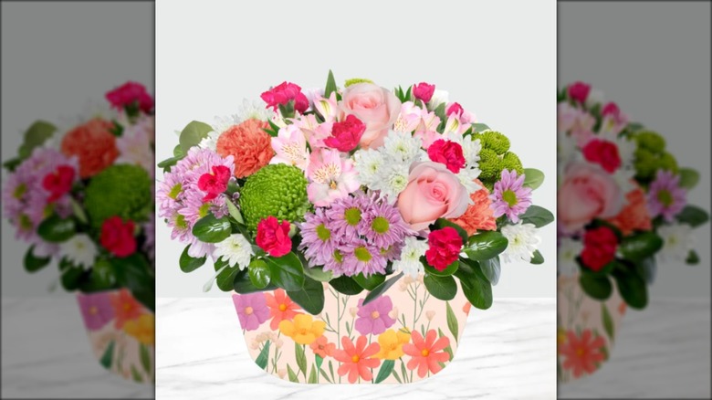 Colorful arrangement of flowers in floral-themed vase.