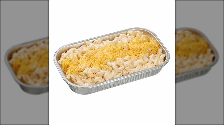 Aluminum tray of macaroni and cheese against white background.