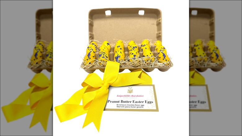 Gift box with yellow and blue peanut butter and chocolate Easter eggs.