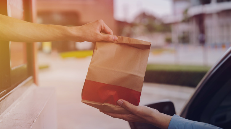 Person being handed a bag in a drive-thru