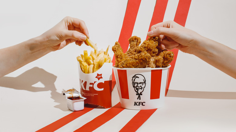 hands hold KFC fried chicken