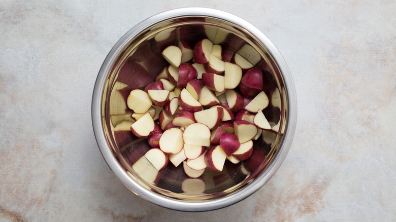 sliced potatoes in mixing bowl