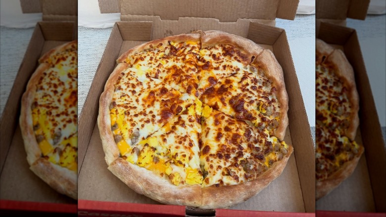 open box of pizza filled with a sausage breakfast pizza