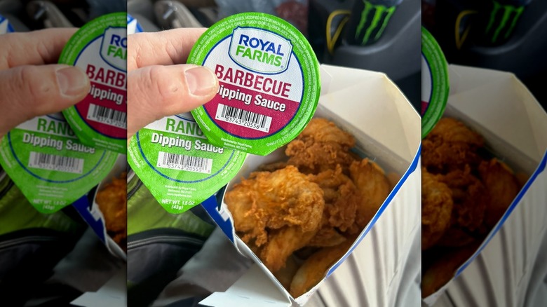 box of chicken tenders with a hand holding ranch and barbecue dipping sauce