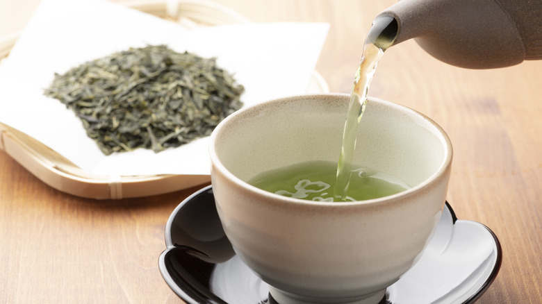 pouring green tea into cup
