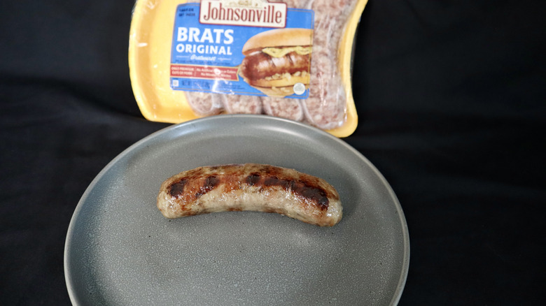Cooked Johnsonville bratwurst on plate with package